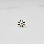 Product shot of a gold nose stud with alternating black onyx and diamond stones
