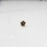 Product shot of a round gold nose stud with blue sapphire gemstone flower cluster