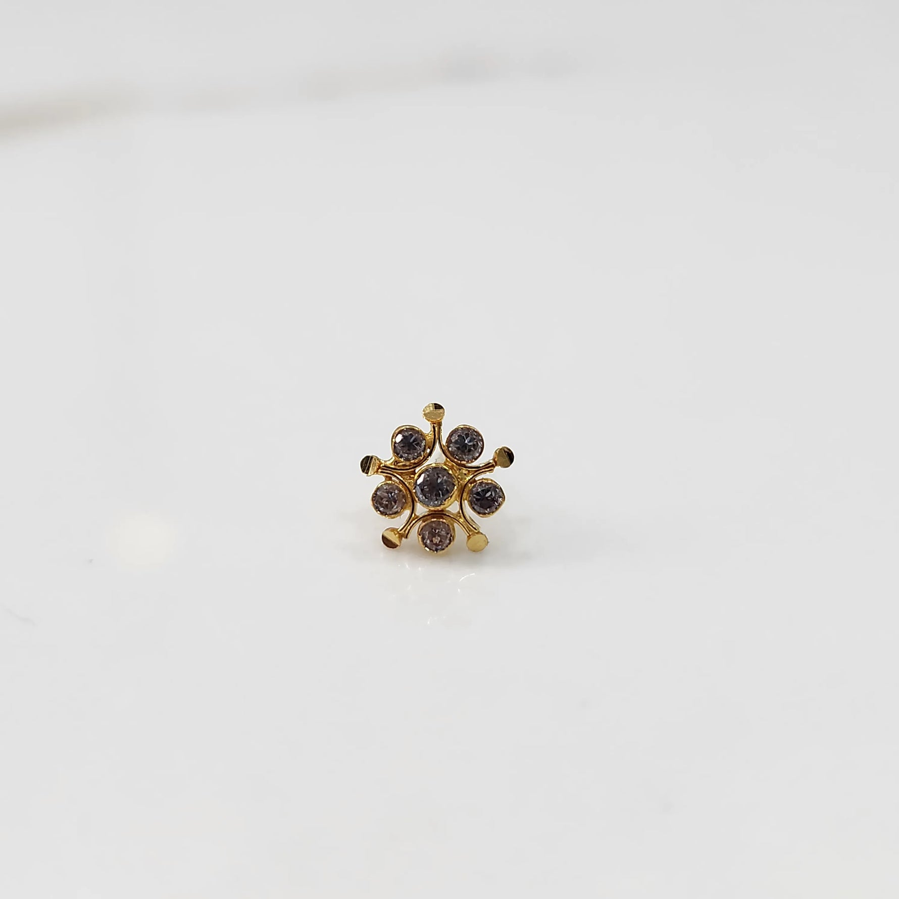 Gold flower nose pin with brown gemstone details