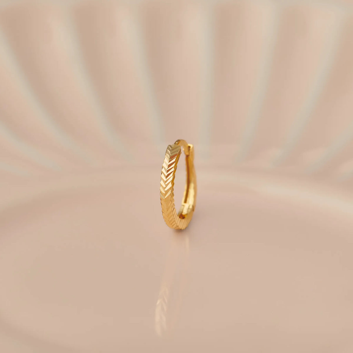 14k gold huggie hoop earring with herringbone/chevron pattern