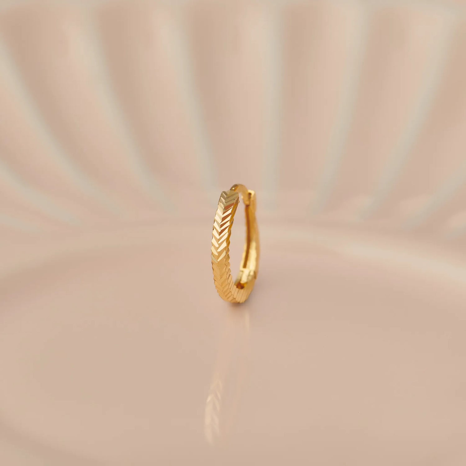 14k gold huggie hoop earring with herringbone/chevron pattern