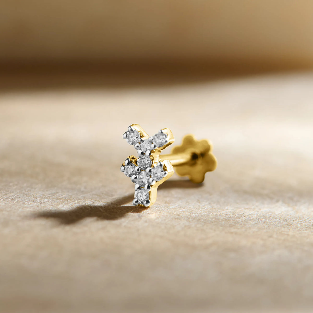 Cross-shaped diamond stud earring in 14k gold