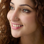 Woman wearing trendy gold nose pin close-up portrait