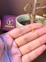 Crown-shaped gold nose pin, small and delicate, held in hand