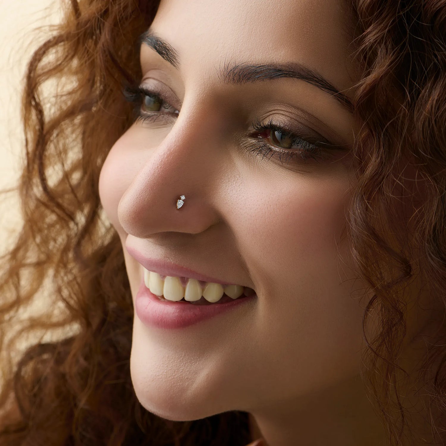 New nose pin design gold shown in a smiling close-up portrait, highlighting a chic and modern nose jewelry look