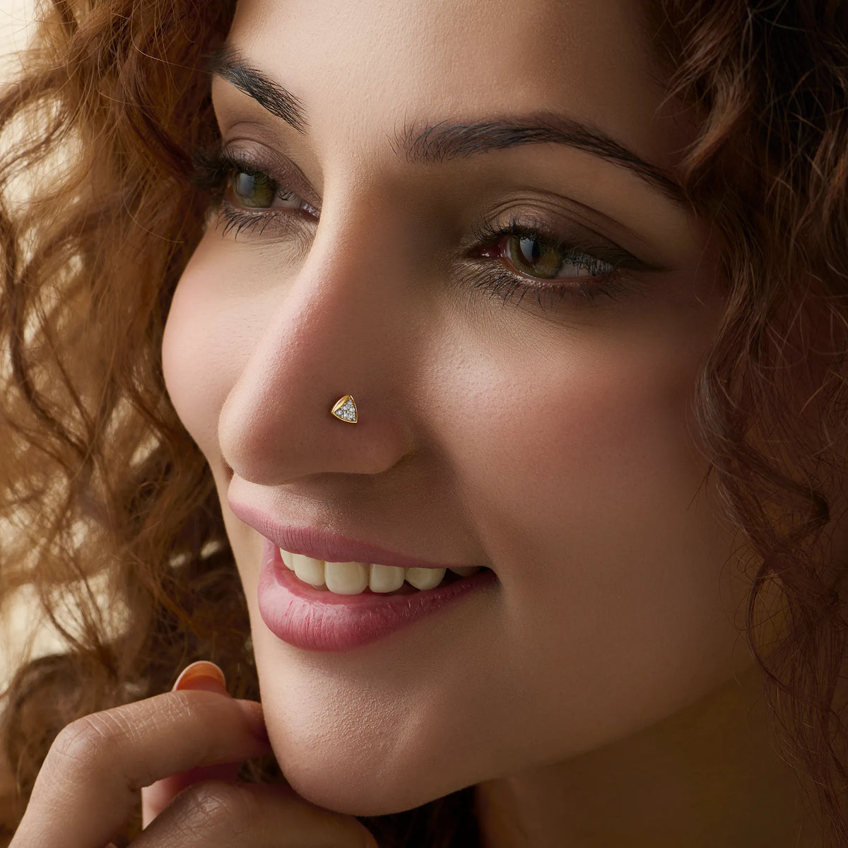 Woman wearing elegant gold triangle nose pin close-up portrait