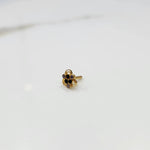 Side tilted view of the stone gold nose pin on a white surface focusing on depth and setting height