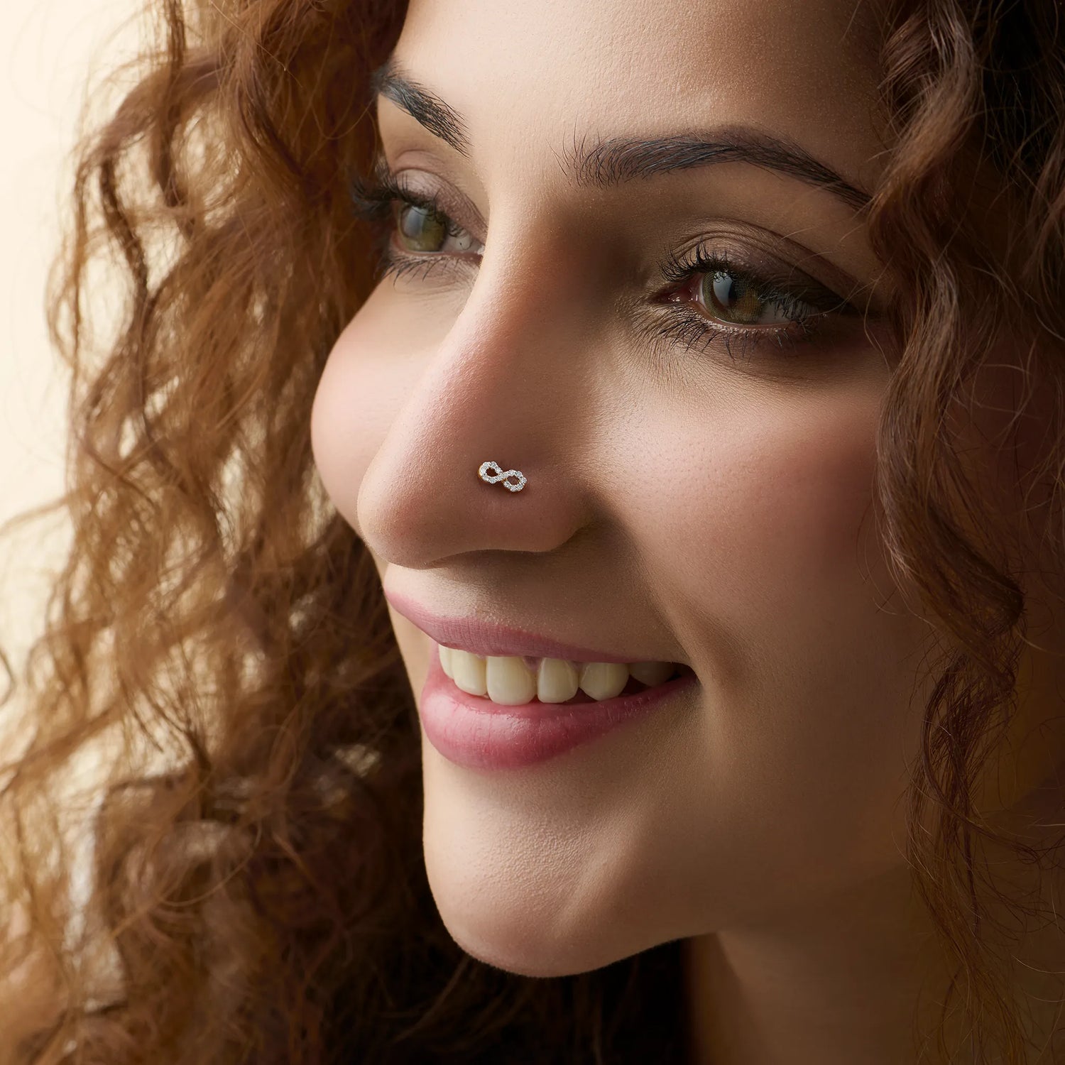 New nose pin design gold worn on the nose in a close-up portrait, highlighting a chic and graceful everyday jewelry look