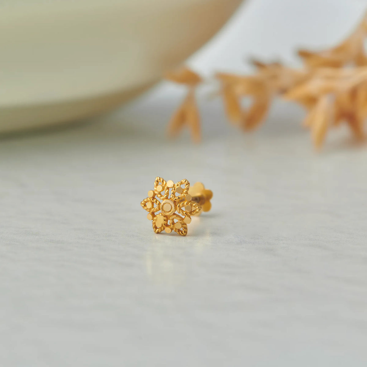 Ornate filigree star-shaped gold stud earring, no gemstone