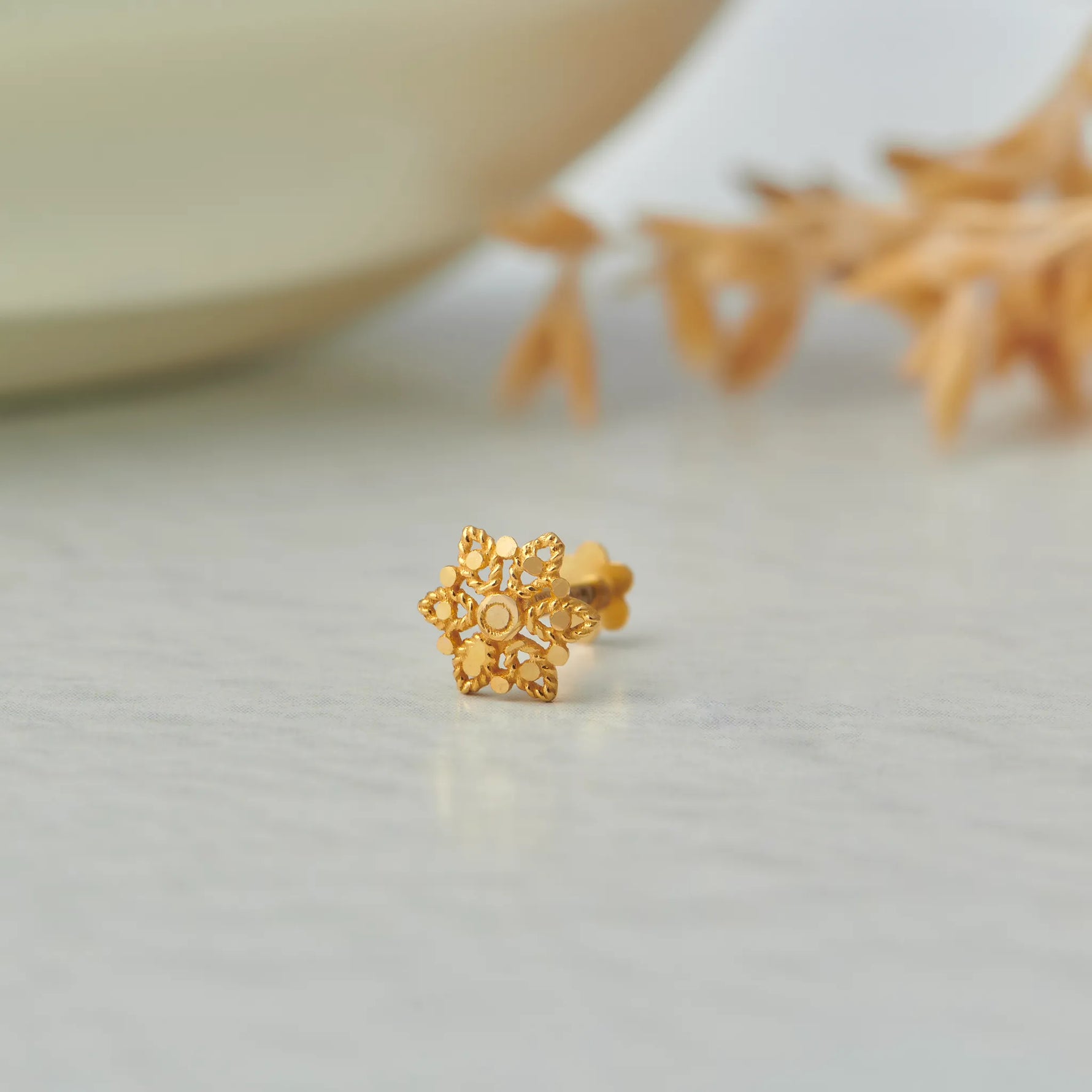 Ornate filigree star-shaped gold stud earring, no gemstone