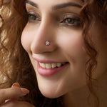 Close-up of woman wearing a nose stud with a pinwheel flower diamond design