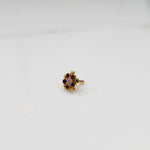Ruby flower cluster nose stud with gold heart setting, jewelry photography