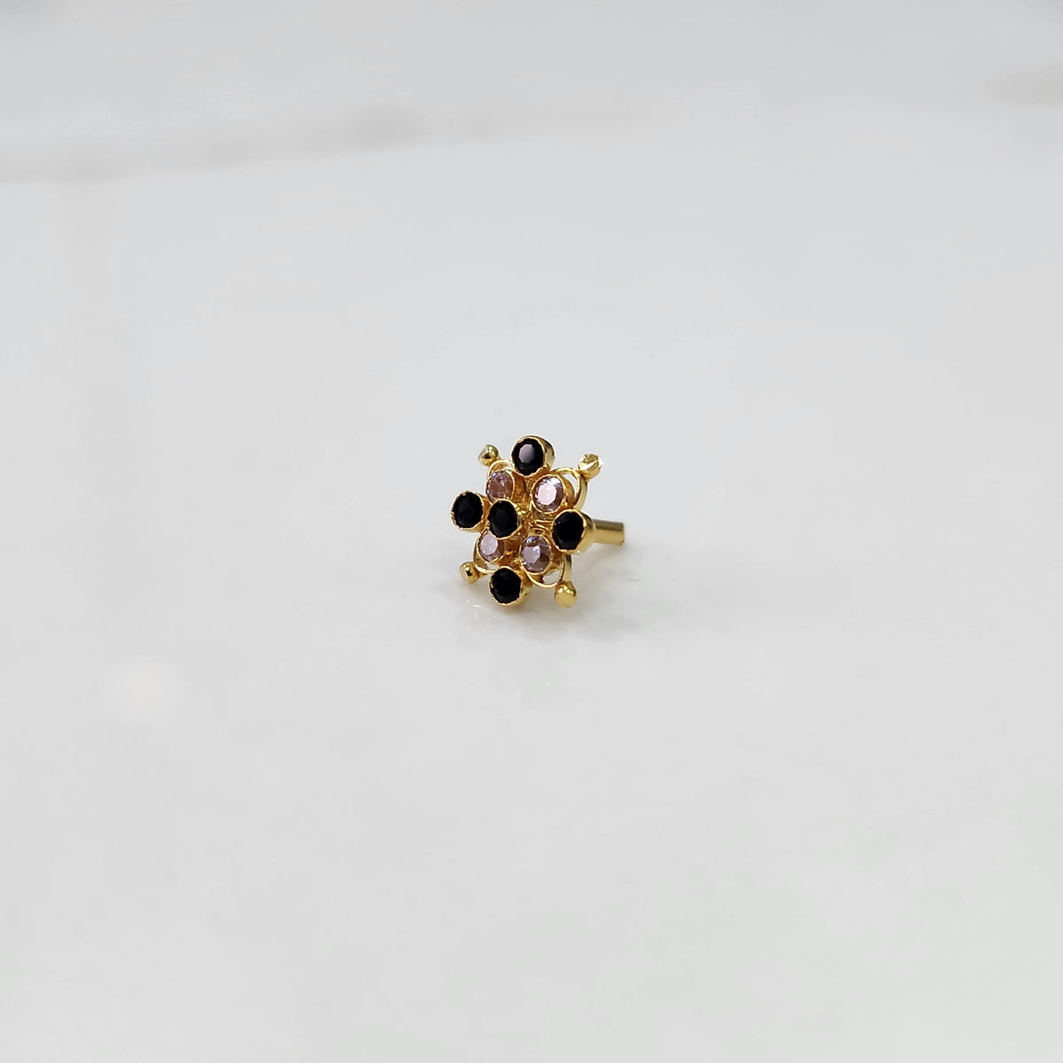 Delicate stone gold nose pin floral design close up