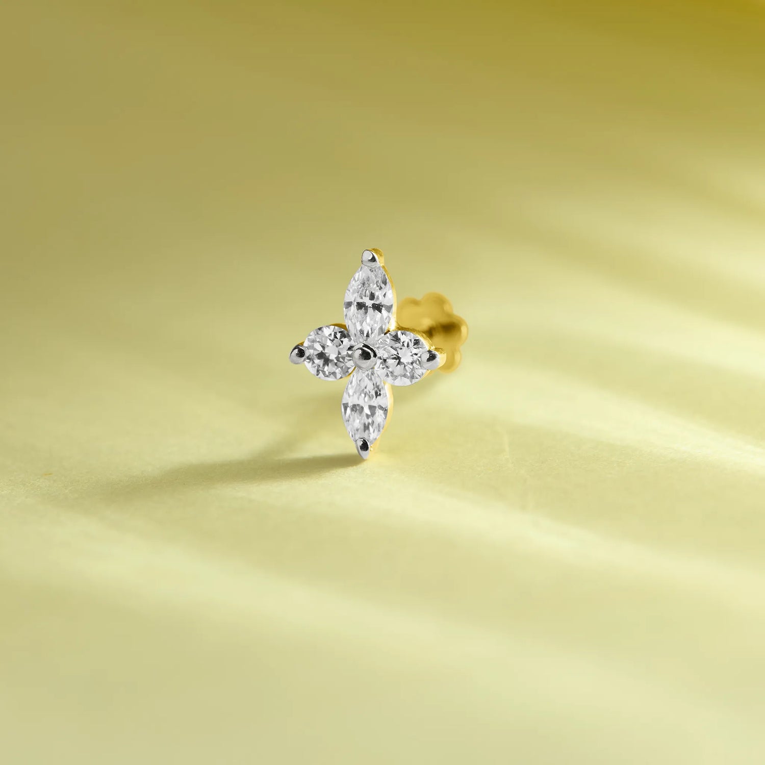 Trending gold nose pin with floral diamond design on soft pastel background
