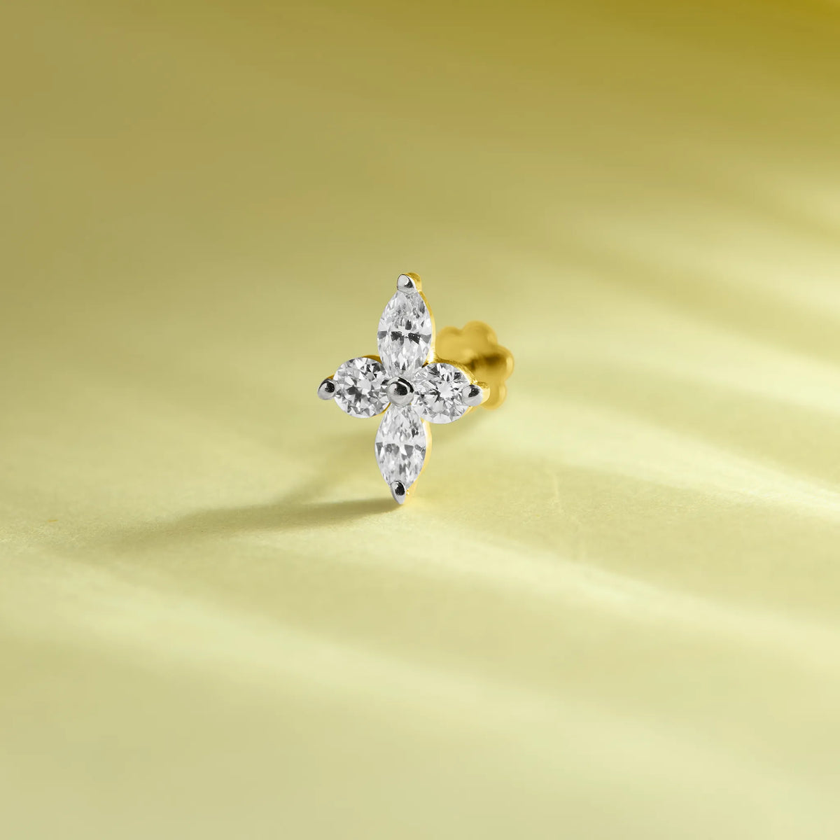 Trending gold nose pin with floral diamond design on soft pastel background