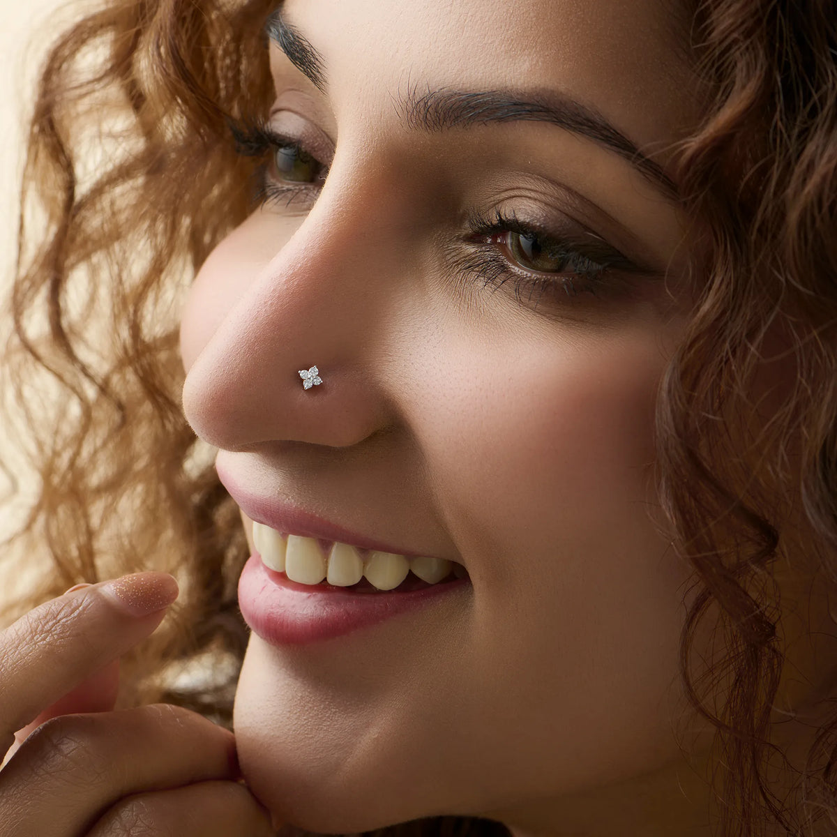 Marquise diamond nose stud worn by a smiling woman, close-up beauty shot