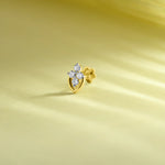 Gold leaf-shaped diamond nose pin design on soft pastel background