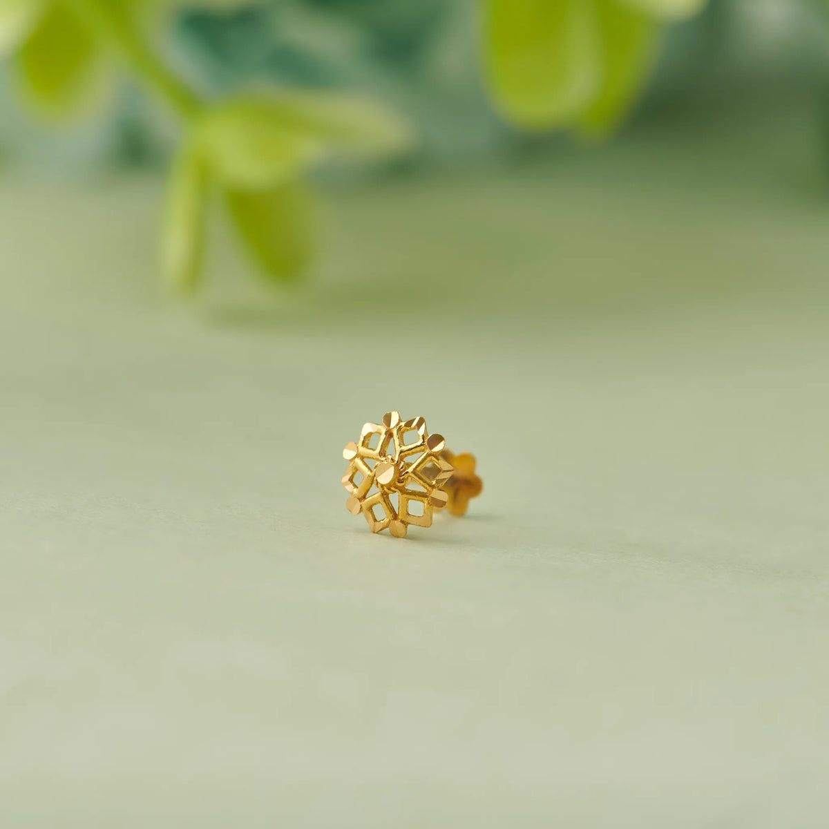 Geometric flower-shaped gold stud earring with diamond cutout petals, no gemstone