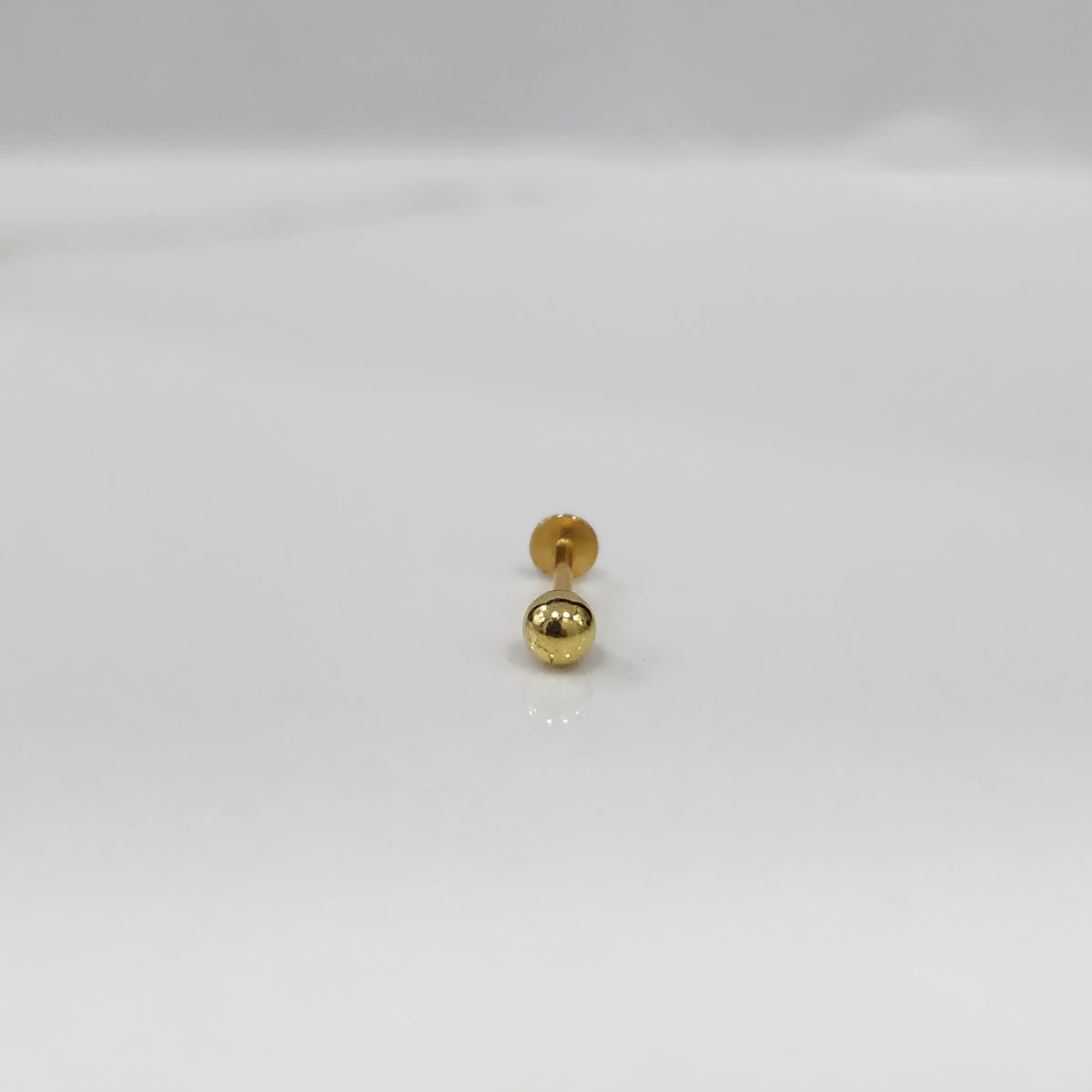 Gold ball flat back stud earring on white background