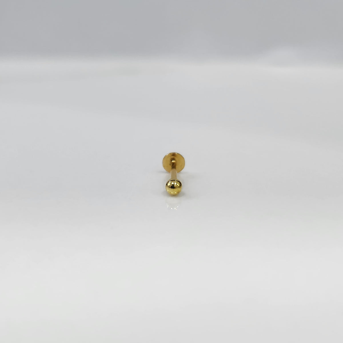 Gold ball flat back stud earring on white background