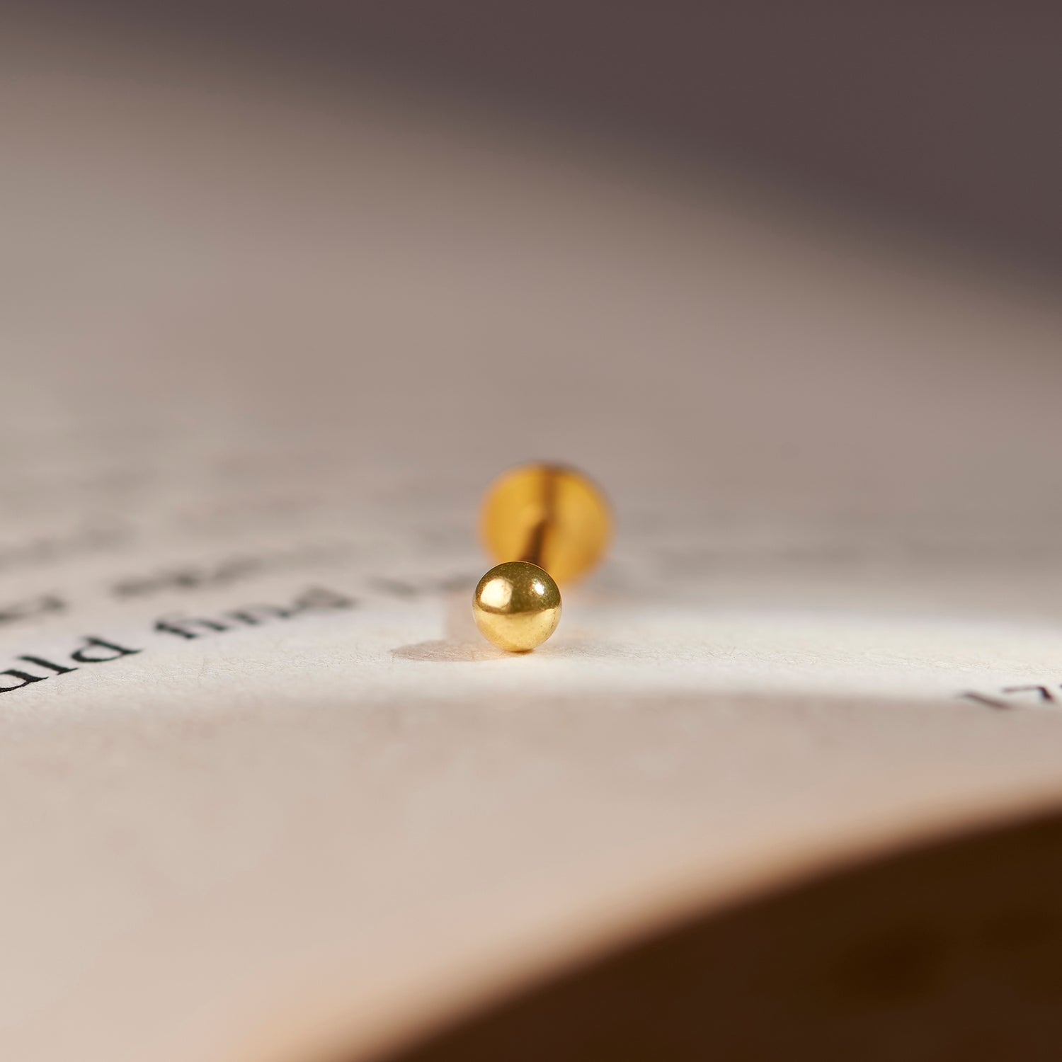 Close-up crop of small gold ball stud