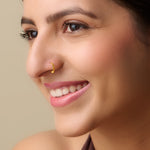 Woman wearing a gold beaded nose ring while smiling