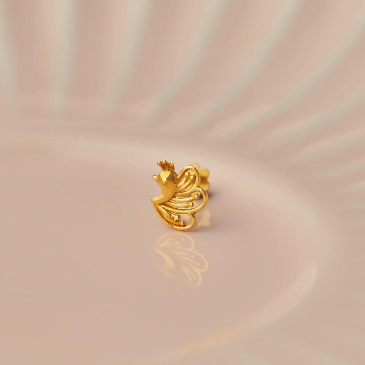 Gold stud earring with bird and flowing feather design