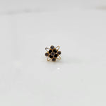 Gold cocktail ring with black and blue gemstones in atomic floral setting