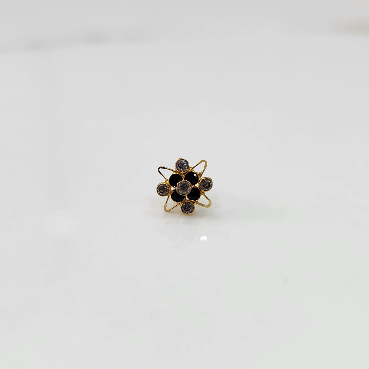Gold cocktail ring with black and blue gemstones in atomic floral setting