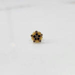 Gold statement ring with black and brown gemstones in textured floral cluster design