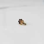 Gold nose pin with black gemstone cluster and clear drop-style stone accent on white background