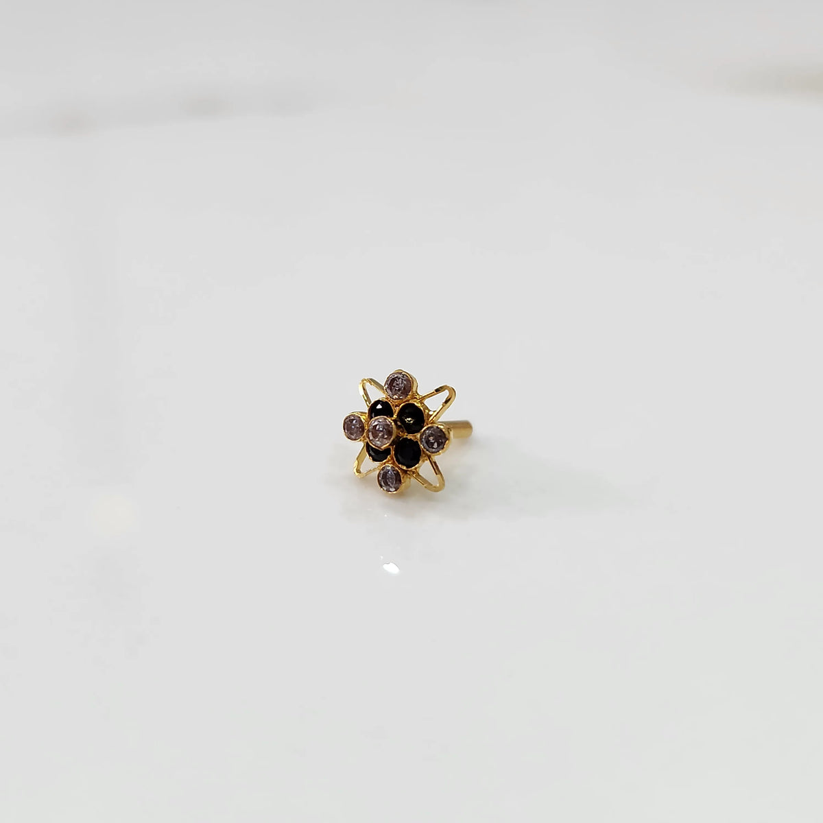Gold statement ring with black and clear gemstones in floral starburst design