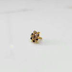 Gold statement ring with black and clear gemstones in leaf-patterned cluster design