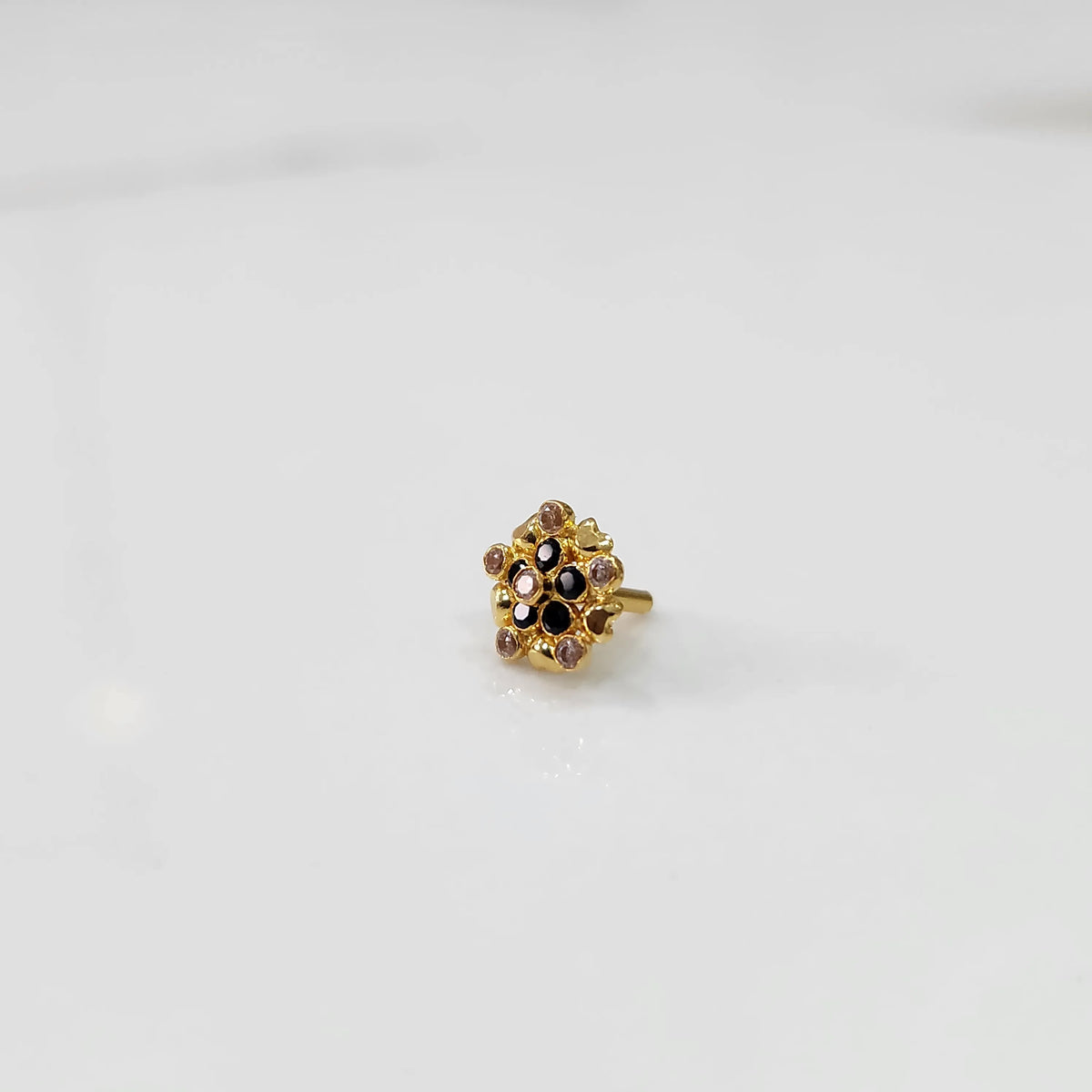 Gold statement ring with black and clear gemstones in textured floral cluster design