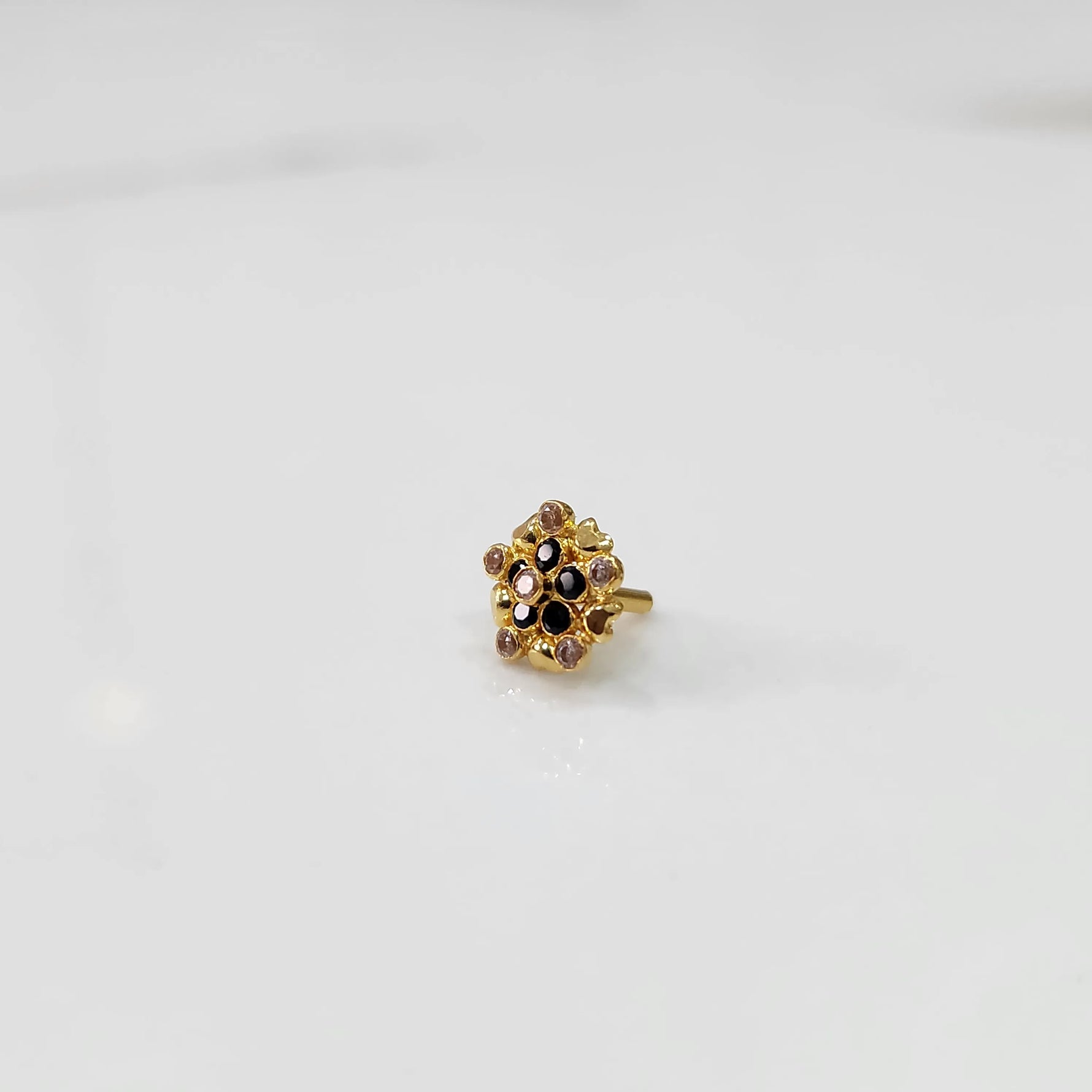 Gold statement ring with black and clear gemstones in textured floral cluster design