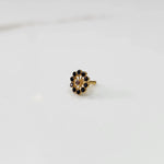 Large gold nose pin with black gemstone petals and center stone accent on white backgroundv