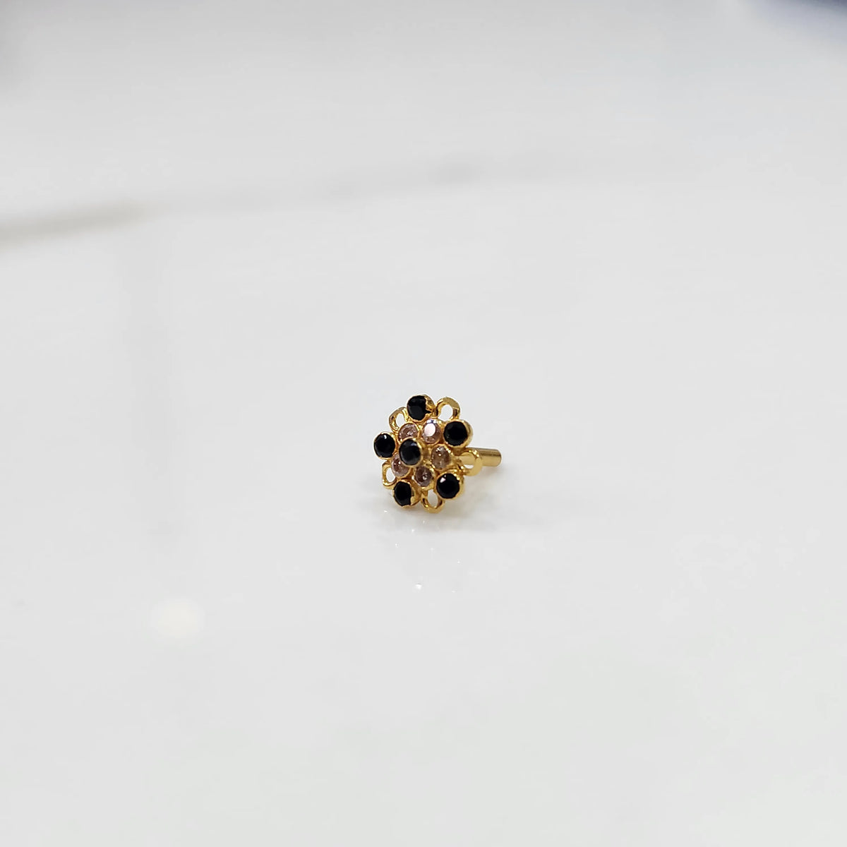 Gold nose pin with black gemstone mandala design on white background