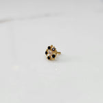 Gold nose pin with black gemstone petals and clear center stone on white background