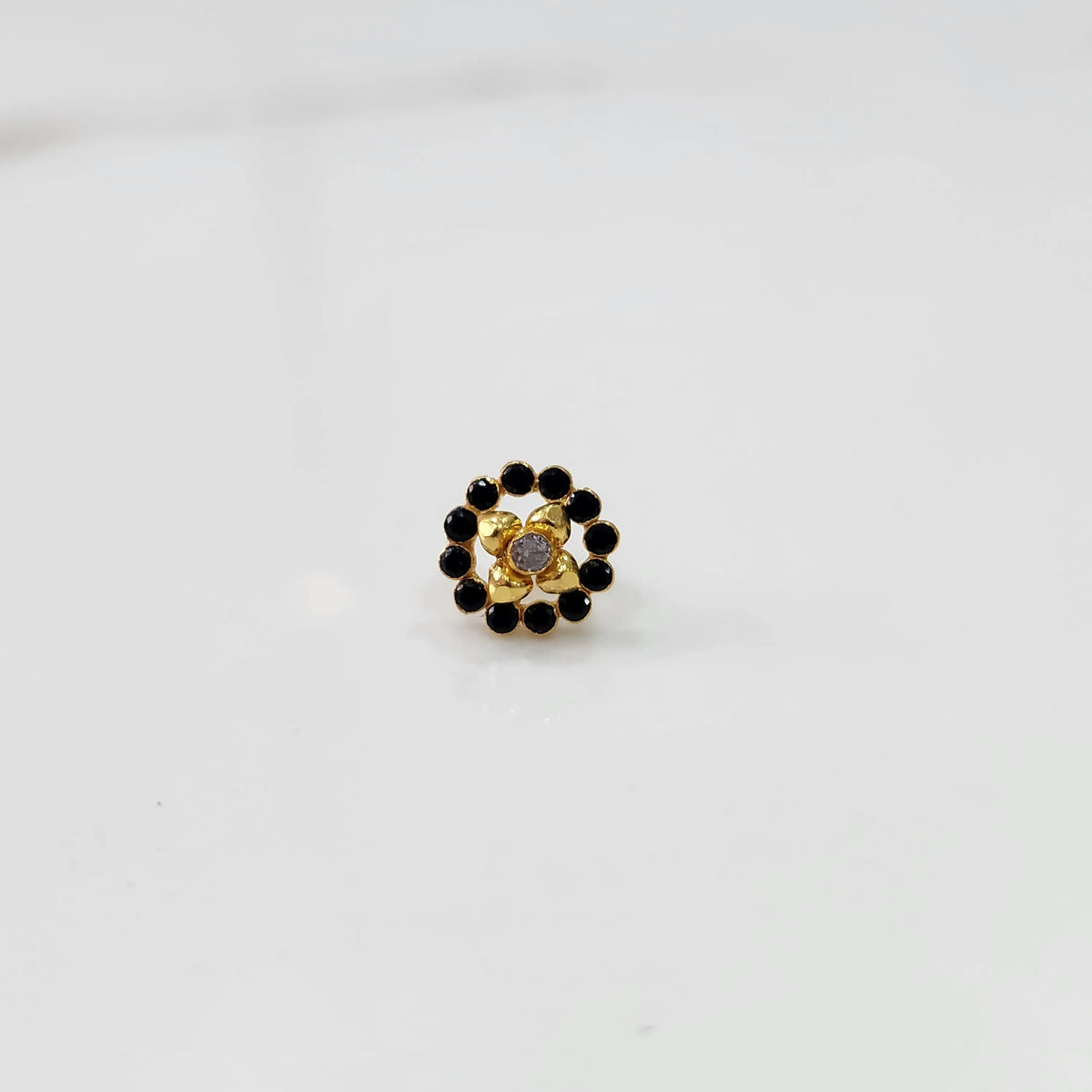 Gold black round nose pin with gemstone border, product shot