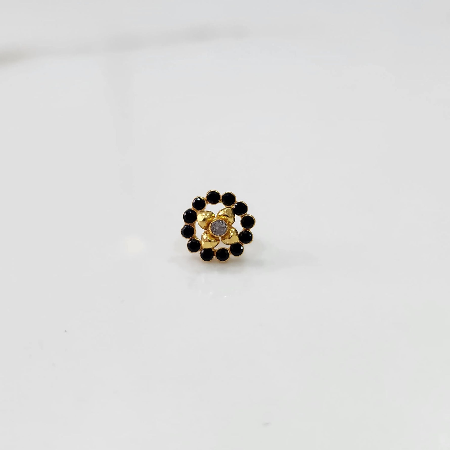 Gold black round nose pin with gemstone border, product shot