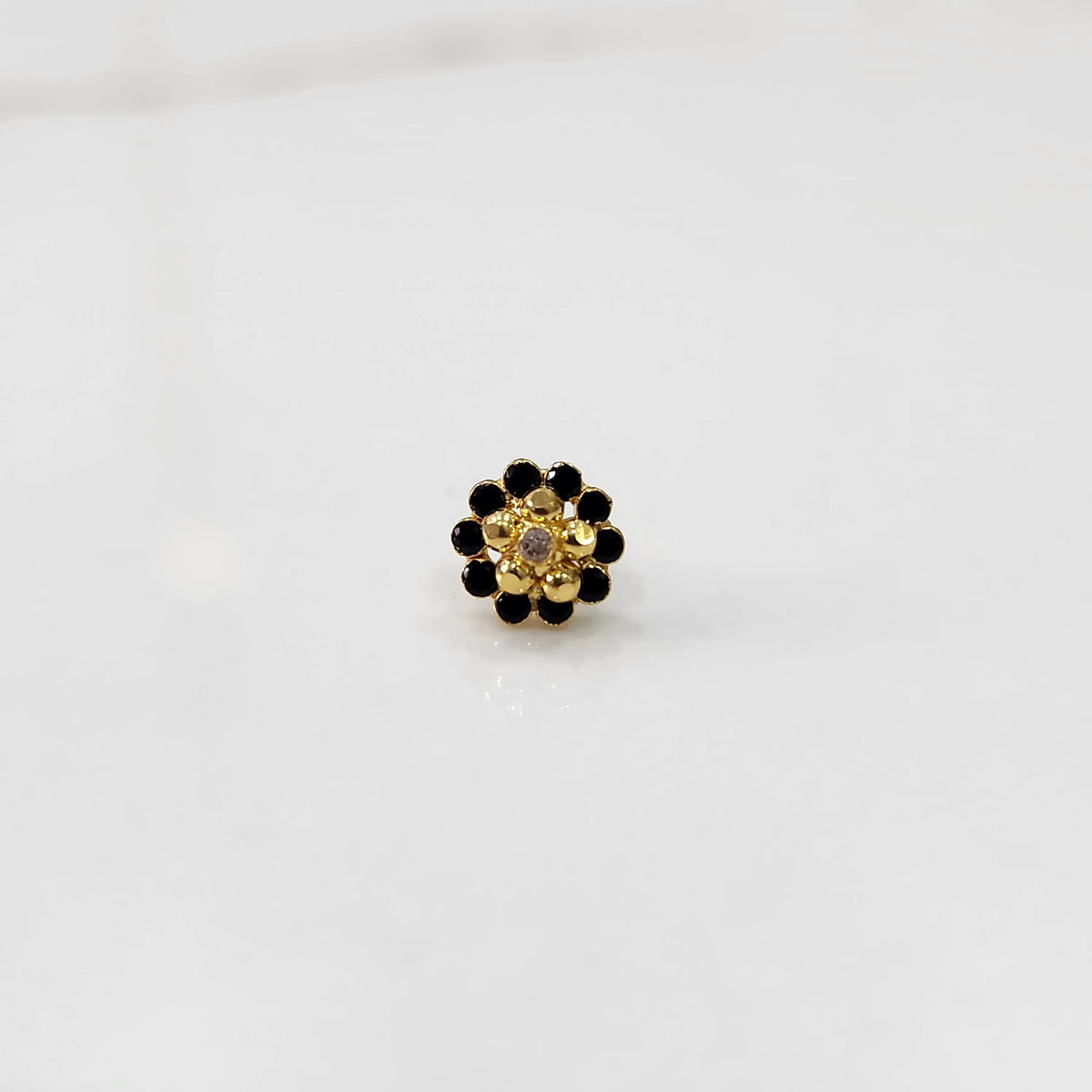 Front view of gold floral ring with black gemstone petals