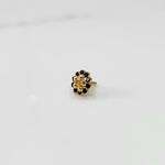 Traditional gold ring featuring black stones around a gold flower design