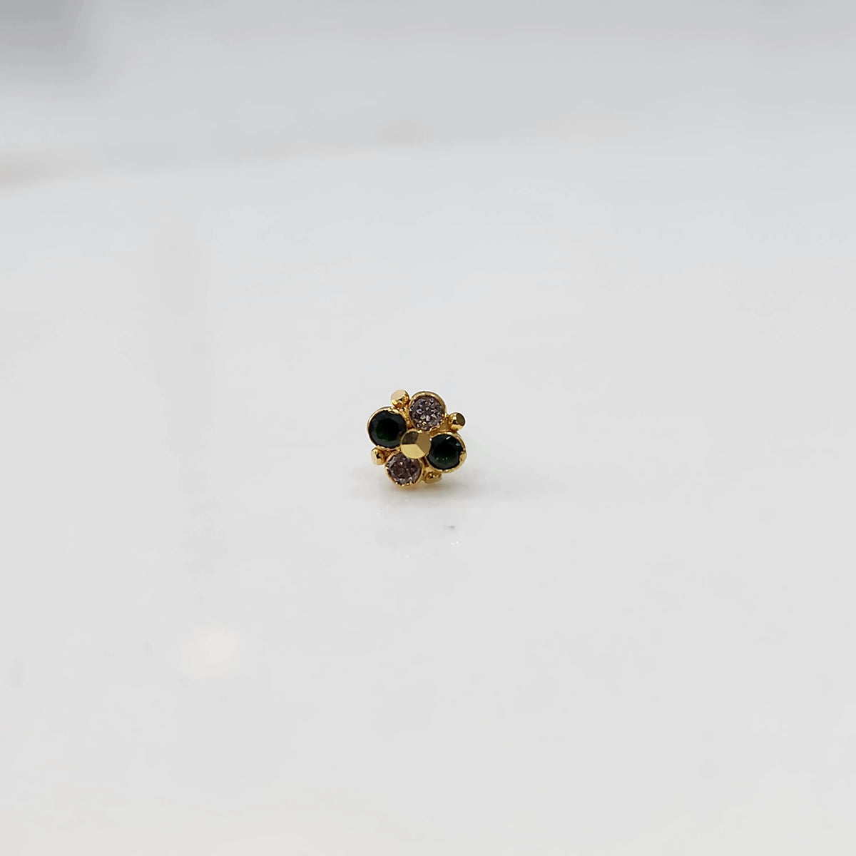 Gold floral nose pin with black and champagne stones, product shot