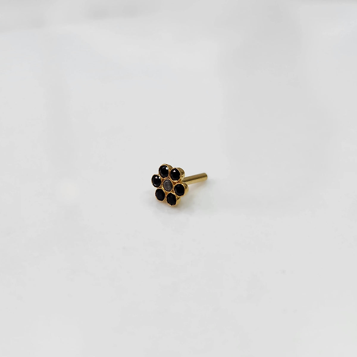 Nose pin design gold with compact floral arrangement on white background
