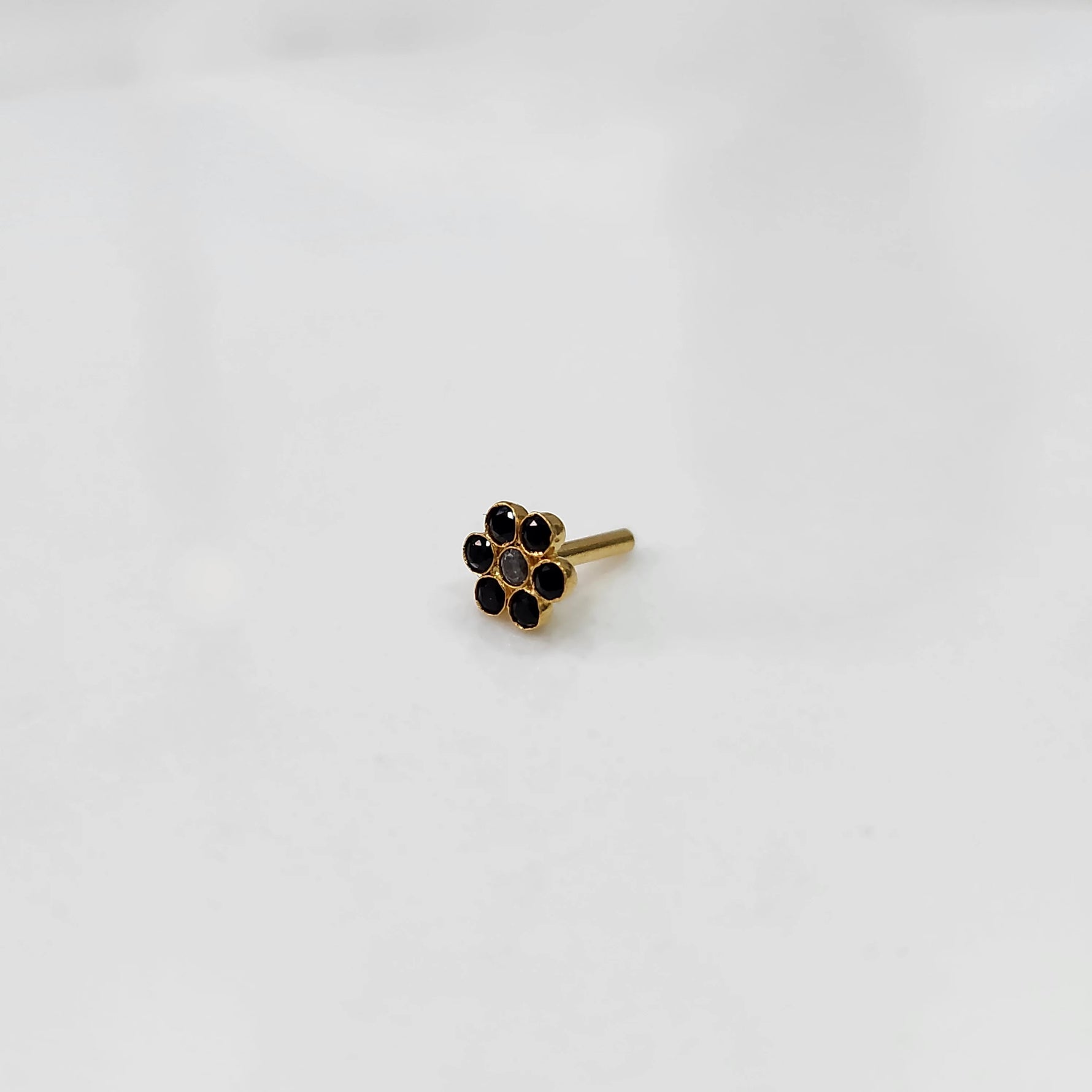 Nose pin design gold with compact floral arrangement on white background
