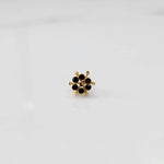 Close-up of gold statement ring with black gemstones in scattered dotted cluster design
