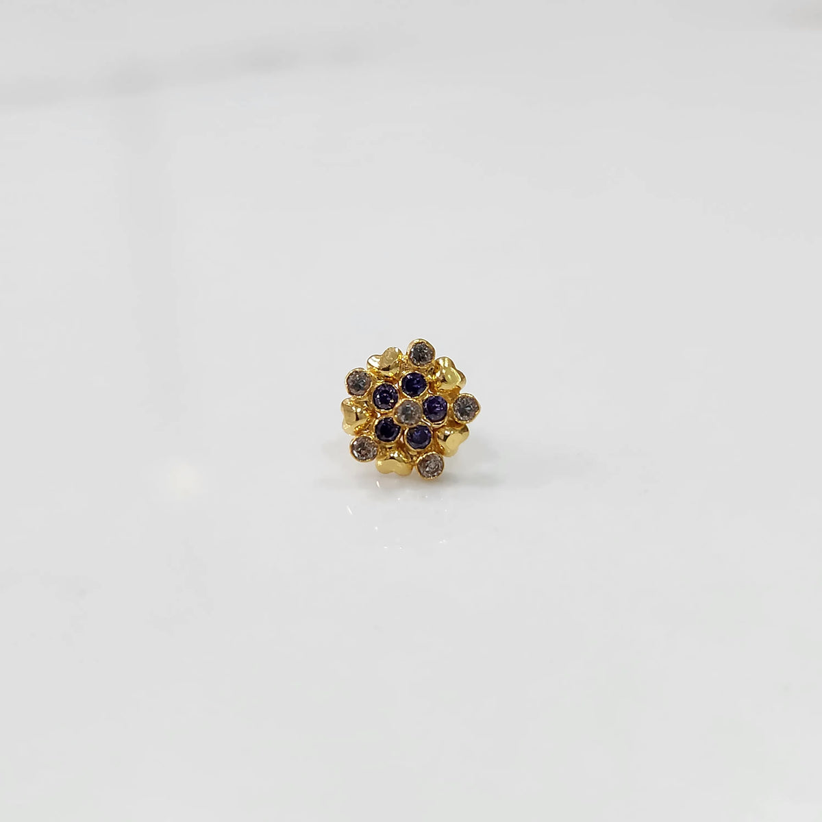Angled view of gold statement ring with blue and brown gemstones in textured cluster design