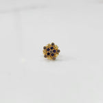 Angled view of gold statement ring with blue and brown gemstones in textured cluster design