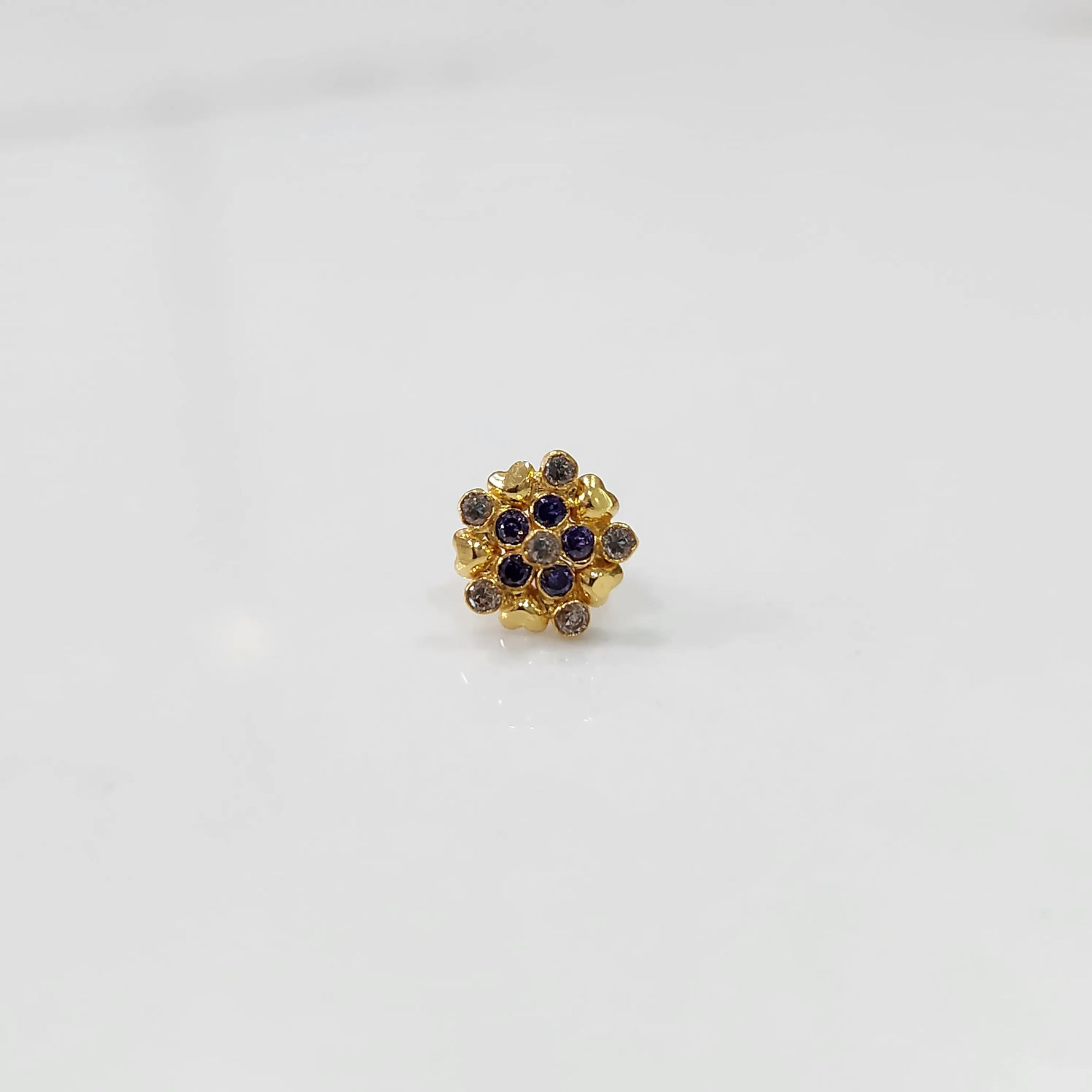 Angled view of gold statement ring with blue and brown gemstones in textured cluster design
