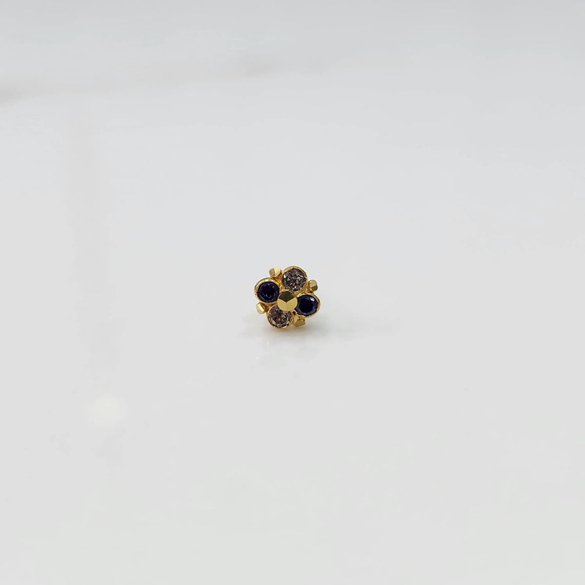 Gold floral nose pin with blue and gold stones, product shot